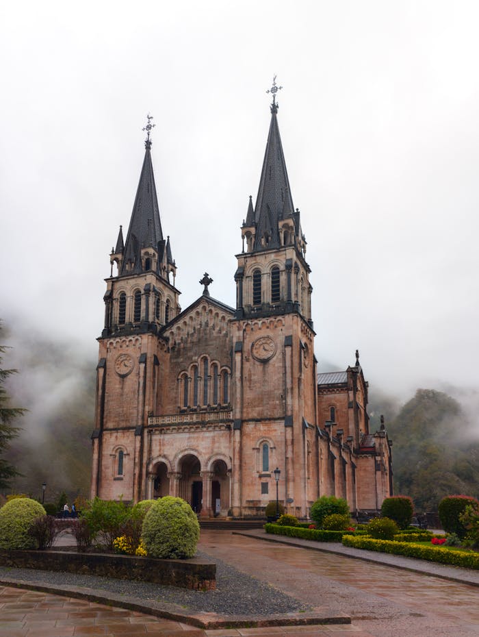 pexels-photo-29566692 Misty view of Basilica de Covadonga, a historic landmark in Asturias, Spain, surrounded by lush greenery.